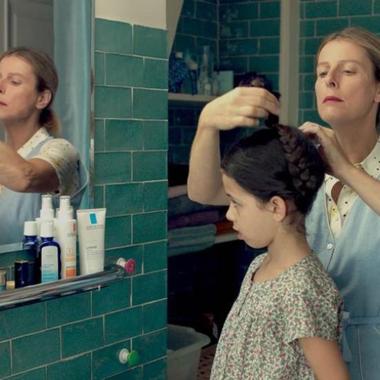 Kvinde på et badeværelse der sætter en mørkhåret piges hår.