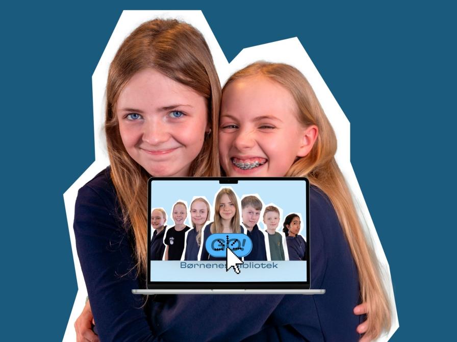 to piger krammer foran en pc med åben skærm, med GO! logo og gruppen som billede, alt sammen på en mærkeblå baggrund